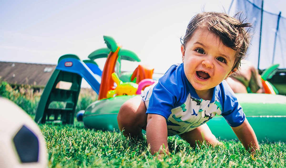 Infant boy playing in the grass